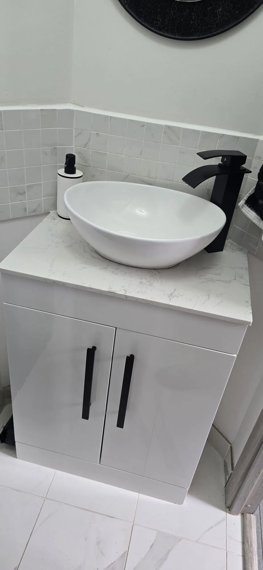 White countertop vessel basin with matte black waterfall tap on a marble vanity in King's Lynn
