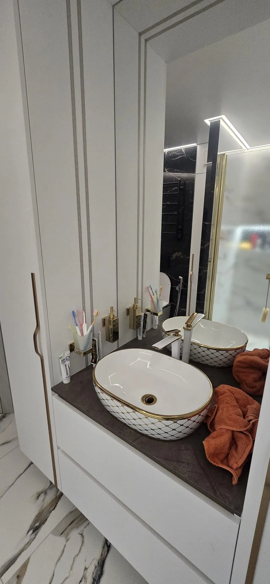 White oval countertop basin with gold trim on a dark vanity unit fitted by A P Kerry Plumbing & Heating